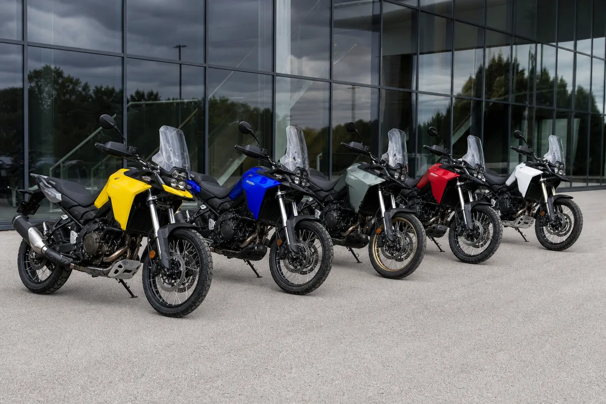 Rangée de motos trail garées devant une concession, réservoirs et roues avant à rayons